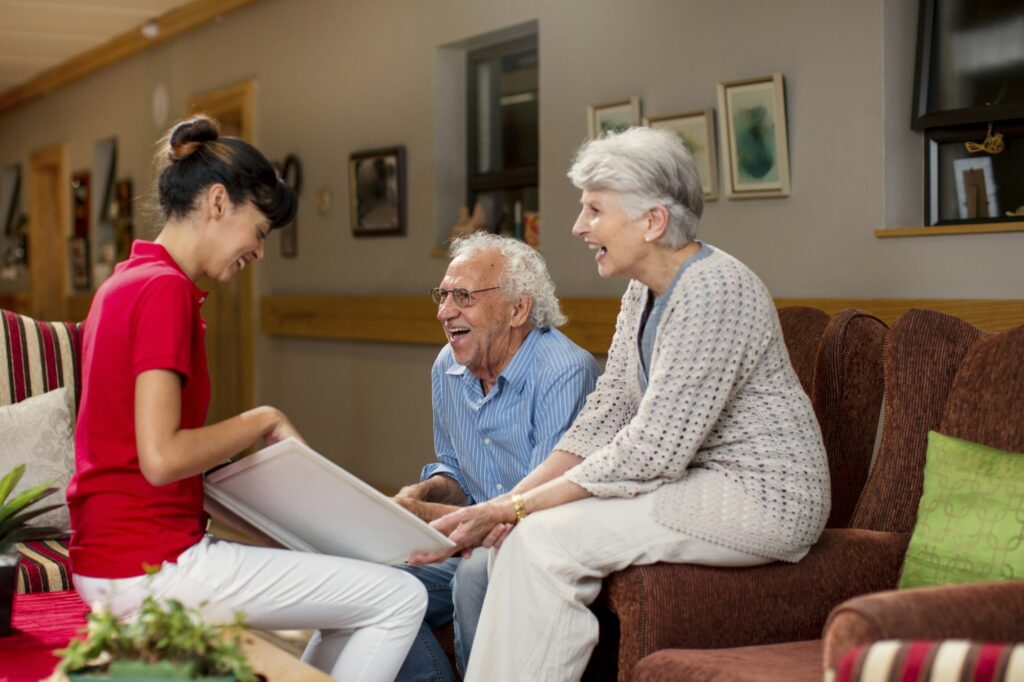 Nurse teaching seniors in retirement home, how to use laptop